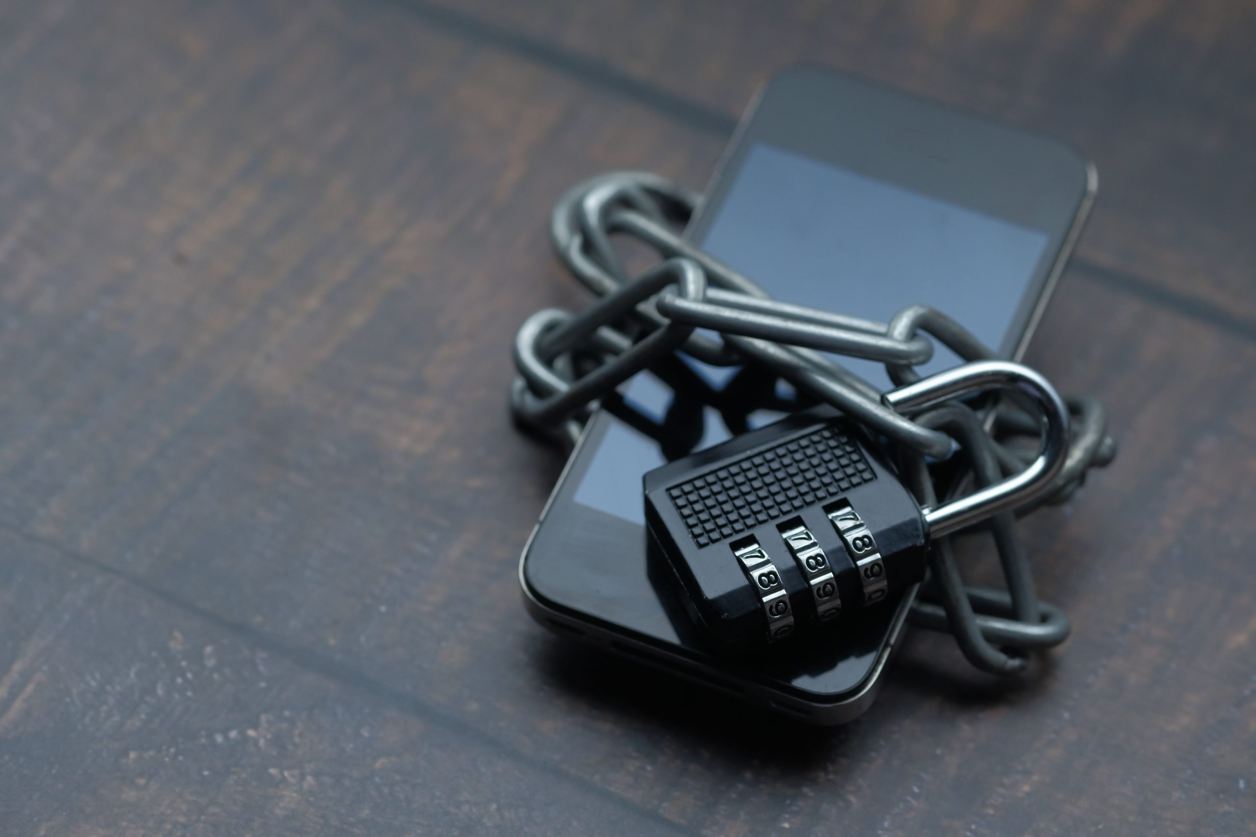 Smartphone secured with a chain and padlock, illustrating the value businesses place on protecting sensitive data.